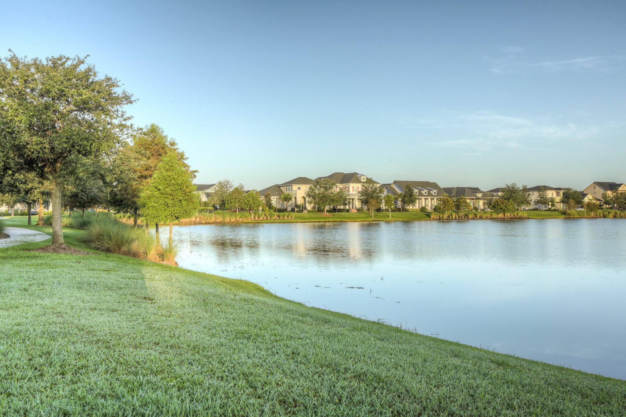 A lake with grass and trees in the foreground.